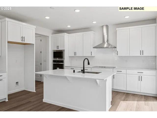 a kitchen with stainless steel appliances granite countertop a sink a stove a refrigerator and cabinets