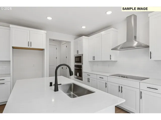 a kitchen with kitchen island stainless steel appliances a sink and cabinets
