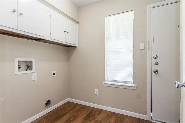 a kitchen with granite countertop a sink cabinets and wooden floor