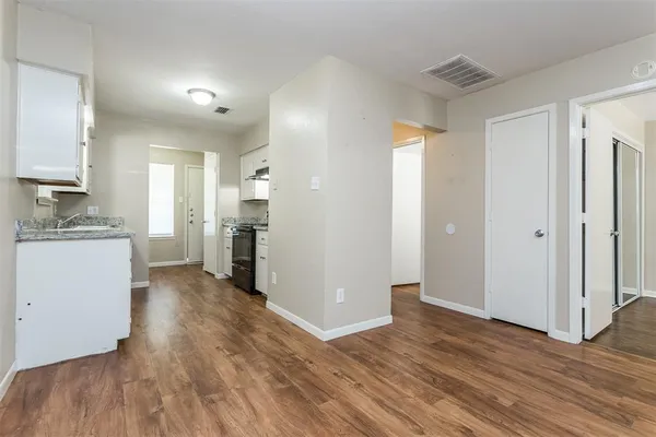 a kitchen with granite countertop wooden floors appliances and sink