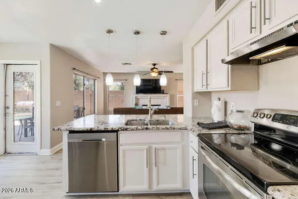 a kitchen with stainless steel appliances granite countertop a sink stove and cabinets