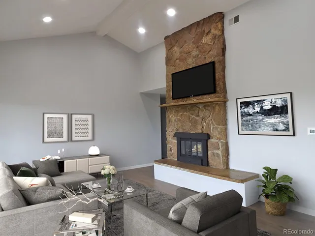 an empty room with wooden floor and a fireplace