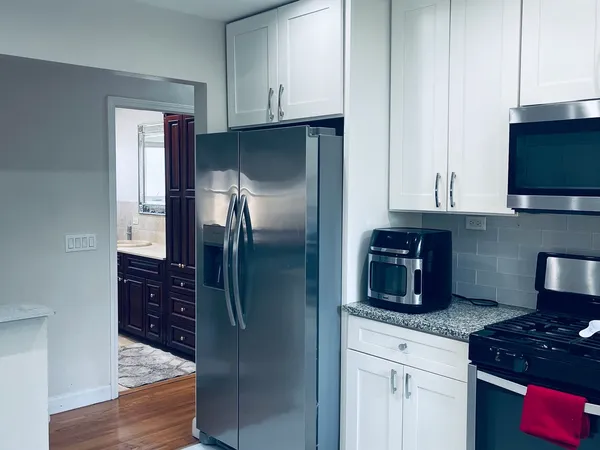 a kitchen with stainless steel appliances granite countertop a refrigerator and a stove top oven