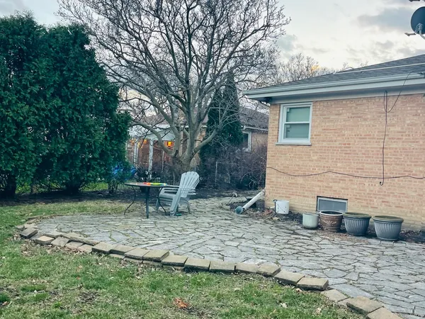 a backyard of a house with table and chairs