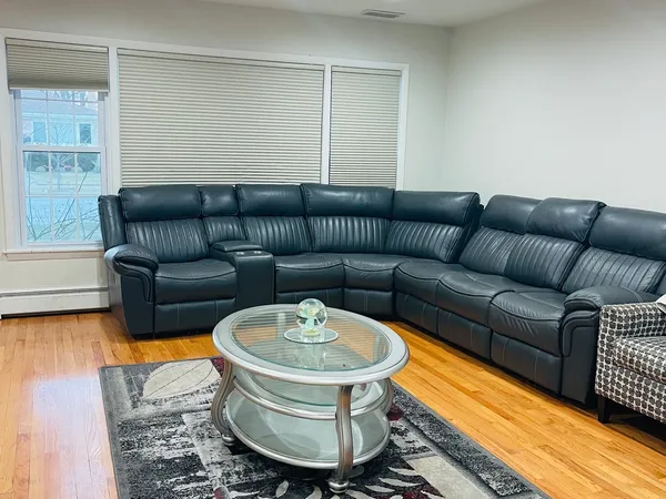 a living room with furniture a rug and a window