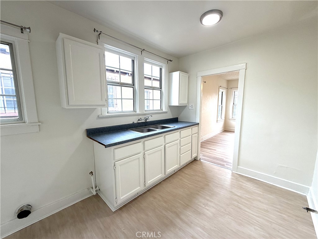 5425 2nd Avenue Los Angeles, CA 90043 - Photo 4 of 10 a kitchen with granite countertop a stove a sink and a refrigerator with wooden floor