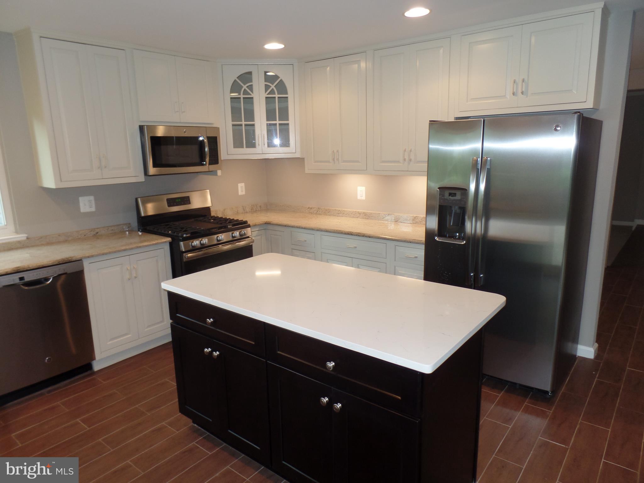 18940 Glendower Road Gaithersburg, MD 20879 - Photo 6 of 30 a kitchen with a sink a microwave a stove and refrigerator