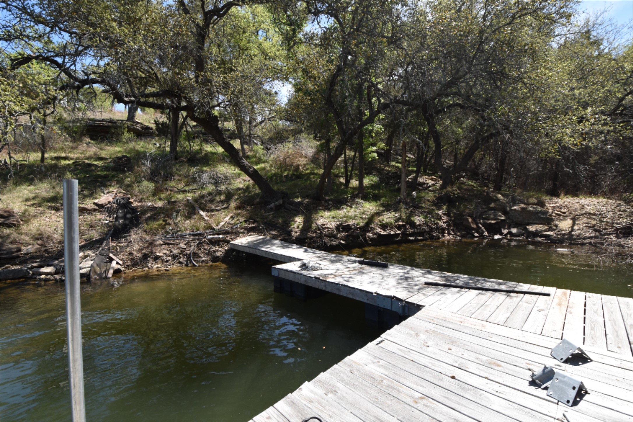 Dock area featuring view of wooded area and overlooking the body of water
