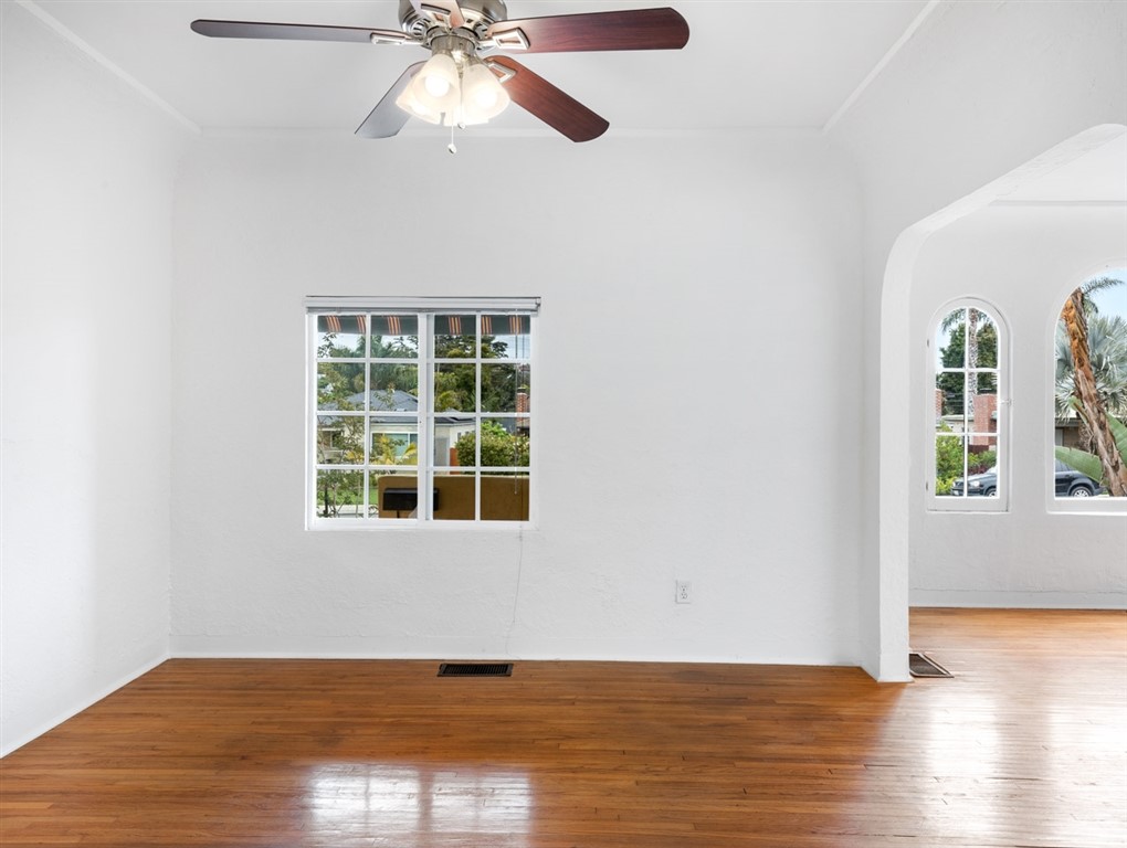 1980 Chatsworth Boulevard San Diego, CA 92107 - Photo 7 of 21 an empty room with wooden floor chandelier fan and windows