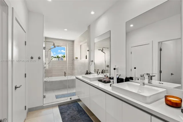 a bathroom with double vanity sinks and a shower