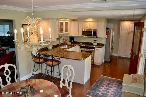 a kitchen with stainless steel appliances granite countertop a stove top oven a sink a dining table and chairs