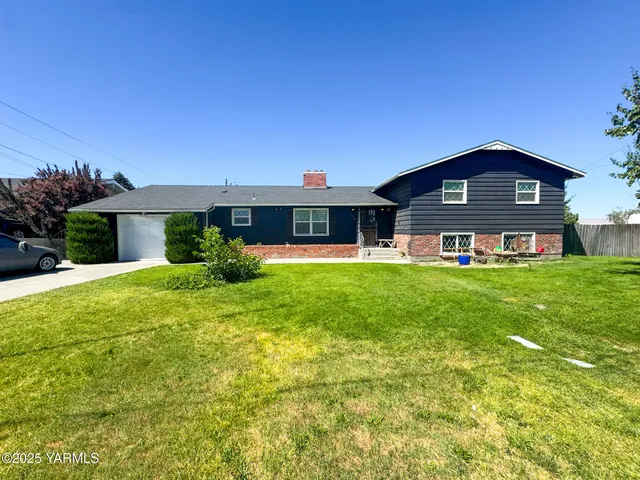 a front view of a house with yard and green space