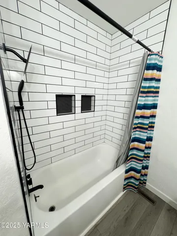 a bathroom with a bathtub and shower