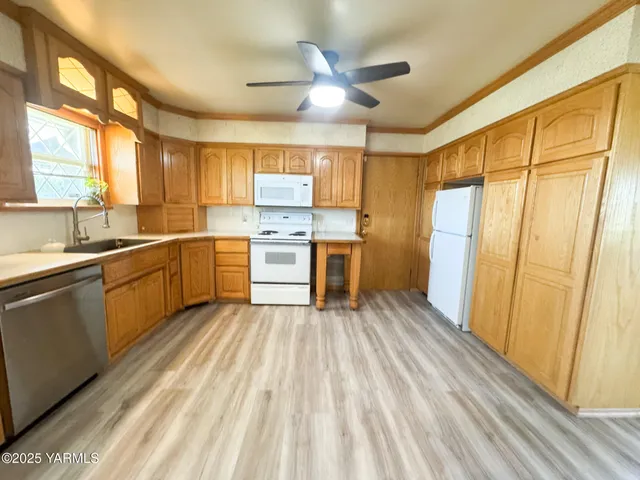 a kitchen with a sink cabinets stainless steel appliances and a large window