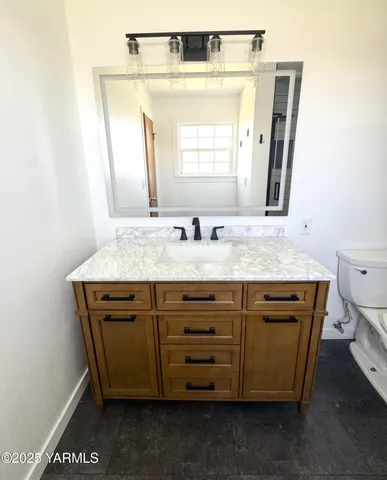 a bathroom with a granite countertop sink and a mirror