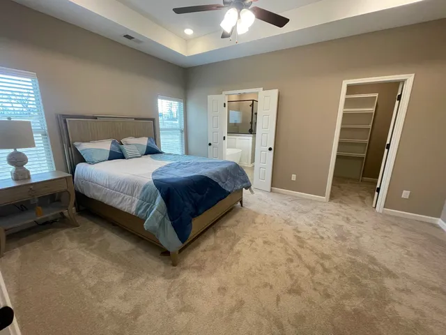 a spacious bedroom with a bed and a chandelier
