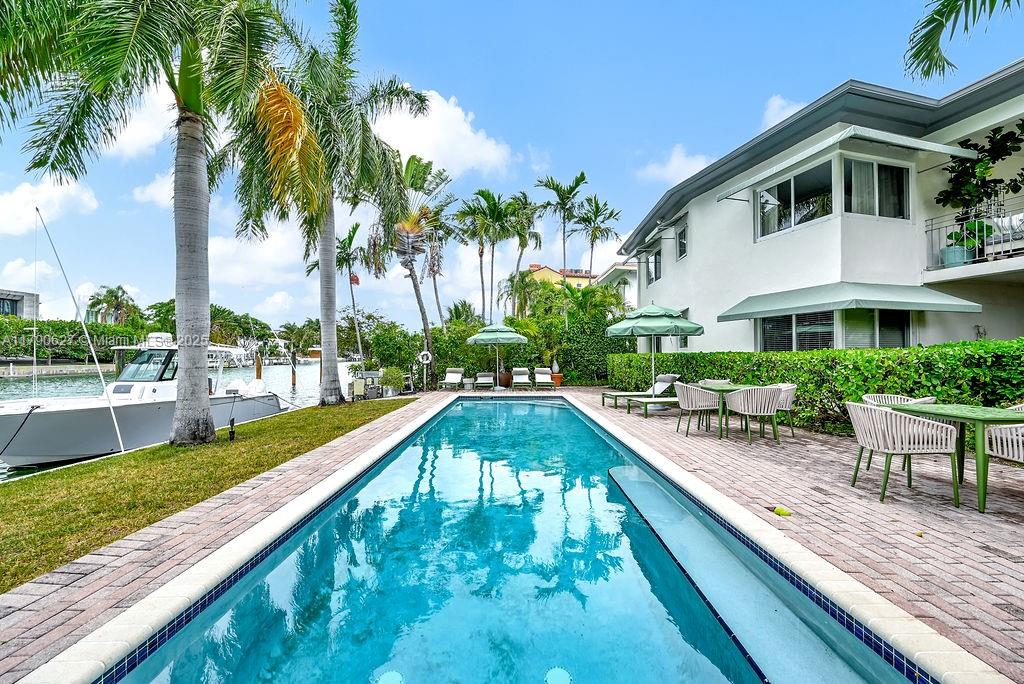 a swimming pool with outdoor seating and yard