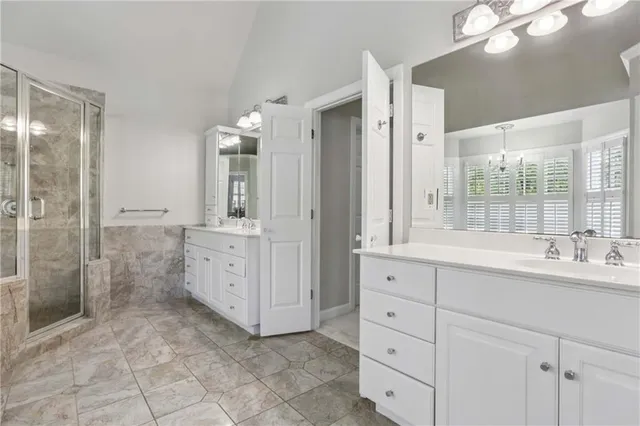 a bathroom with a double vanity sink mirror and shower