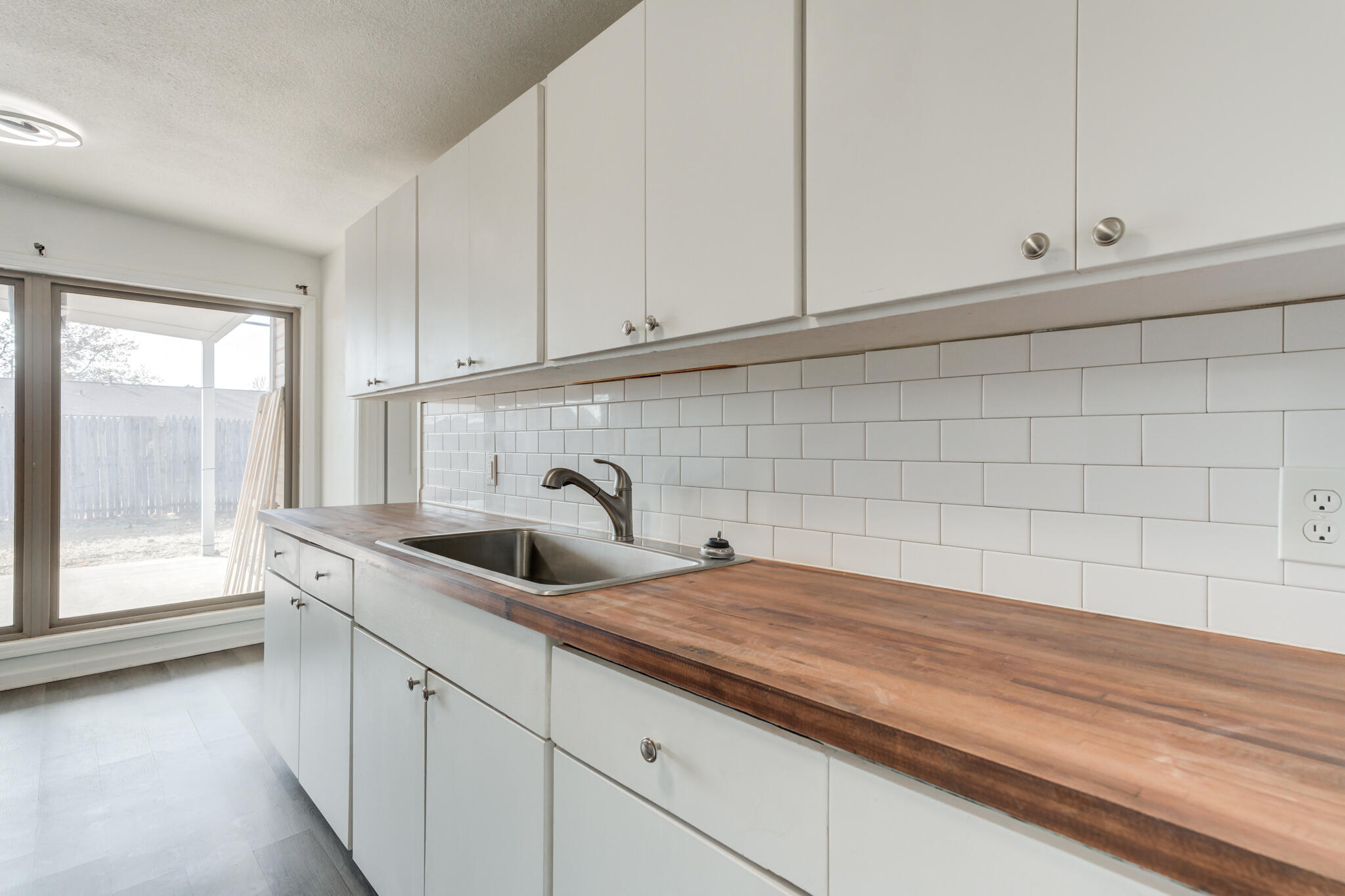 2803 66th Street Lubbock, TX 79413 - Photo 3 of 23 a kitchen with granite countertop white cabinets and sink