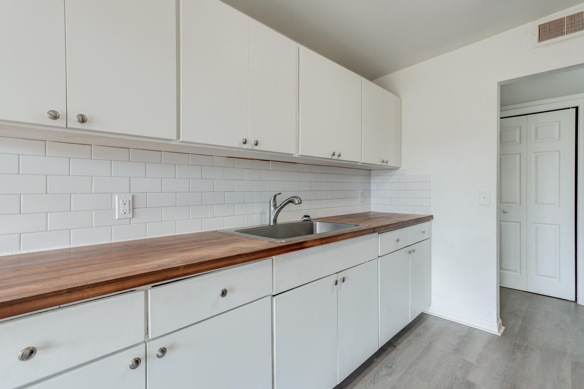 2803 66th Street Lubbock, TX 79413 - Photo 5 of 23 a kitchen with white cabinets and a sink