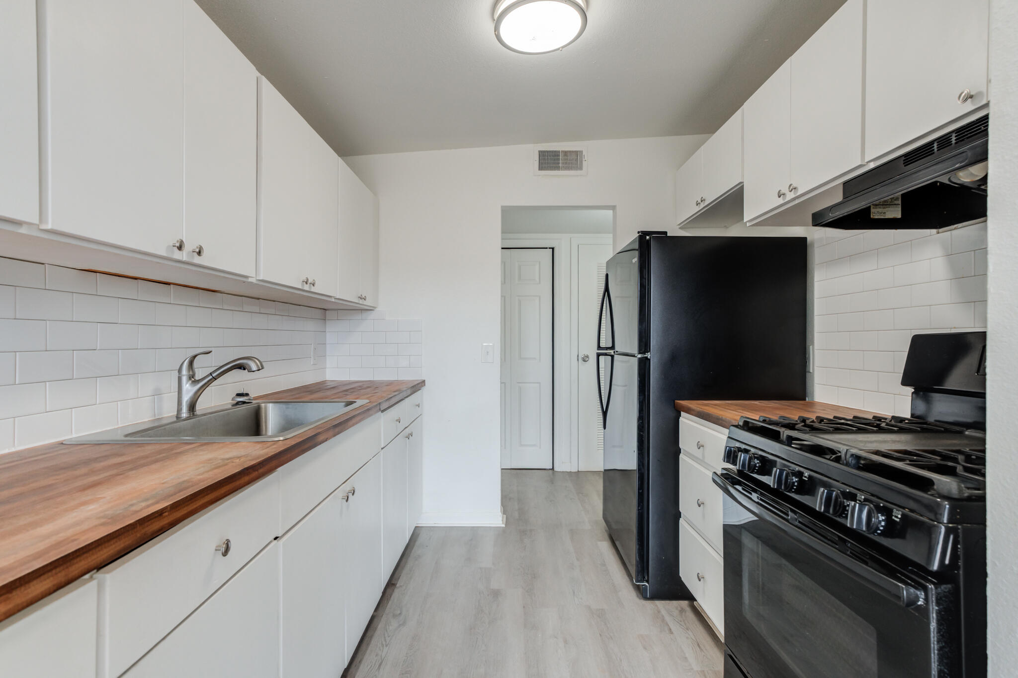 2803 66th Street Lubbock, TX 79413 - Photo 8 of 23 a kitchen with a sink stove and refrigerator