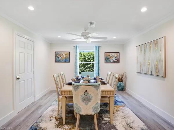 a dining room with furniture a large window and wooden floor