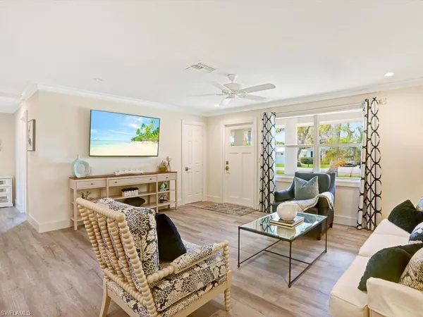 a living room with furniture a flat screen tv and a floor to ceiling window