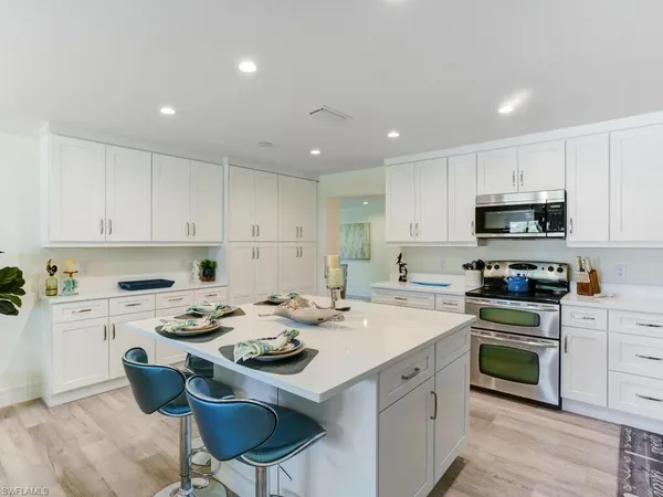 a kitchen with a stove a sink a dining table and chairs
