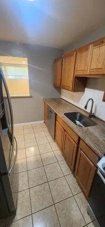 a kitchen with a sink a counter top space and cabinets