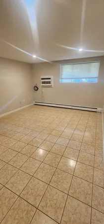a view of a refrigerator in kitchen and an empty room