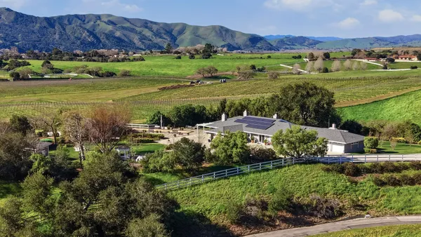 a view of a lush green hillside and houses