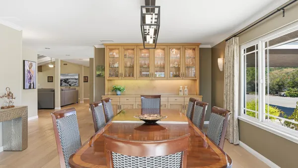 a dining room with furniture a chandelier and window