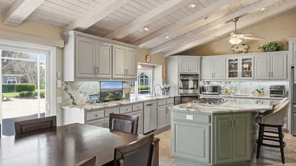 a kitchen with stainless steel appliances granite countertop a sink stove cabinets and refrigerator