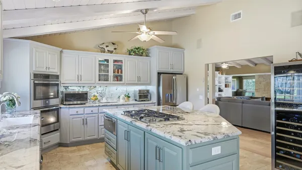 a kitchen with stainless steel appliances granite countertop a sink stove and cabinets