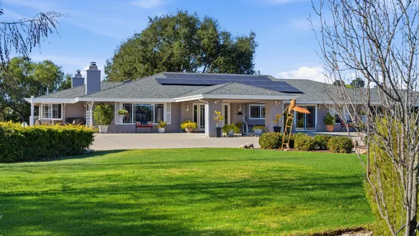 a front view of a house with a garden