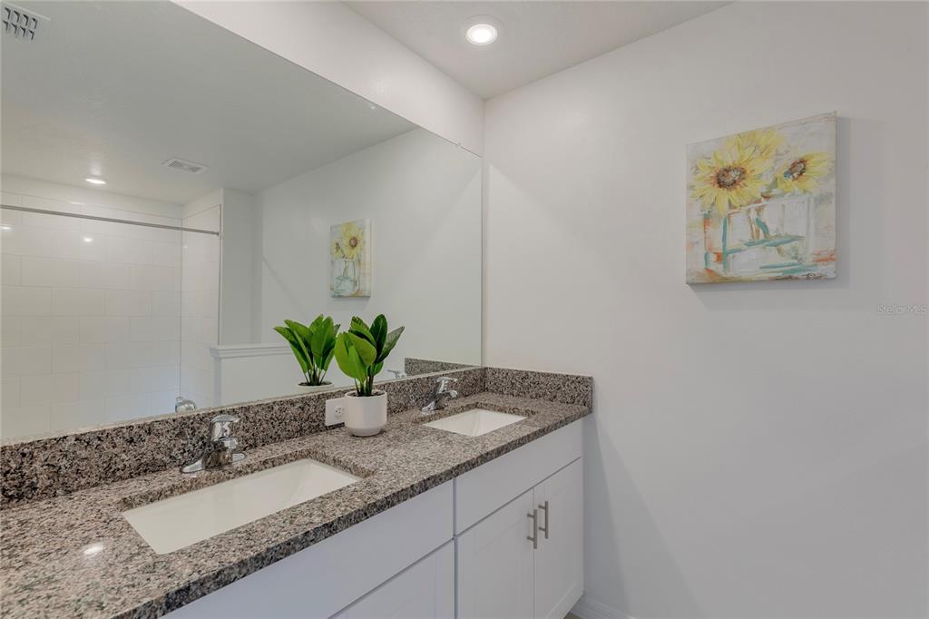 11091 Wishing Cloud Road Land O Lakes, FL 34638 - Photo 14 of 25 a bathroom with a granite countertop sink a mirror and vanity