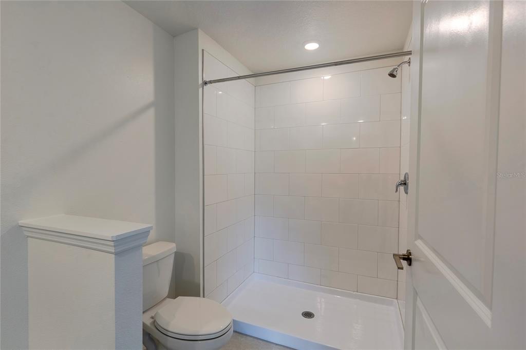 11091 Wishing Cloud Road Land O Lakes, FL 34638 - Photo 15 of 25 a bathroom with a shower a toilet and a shower