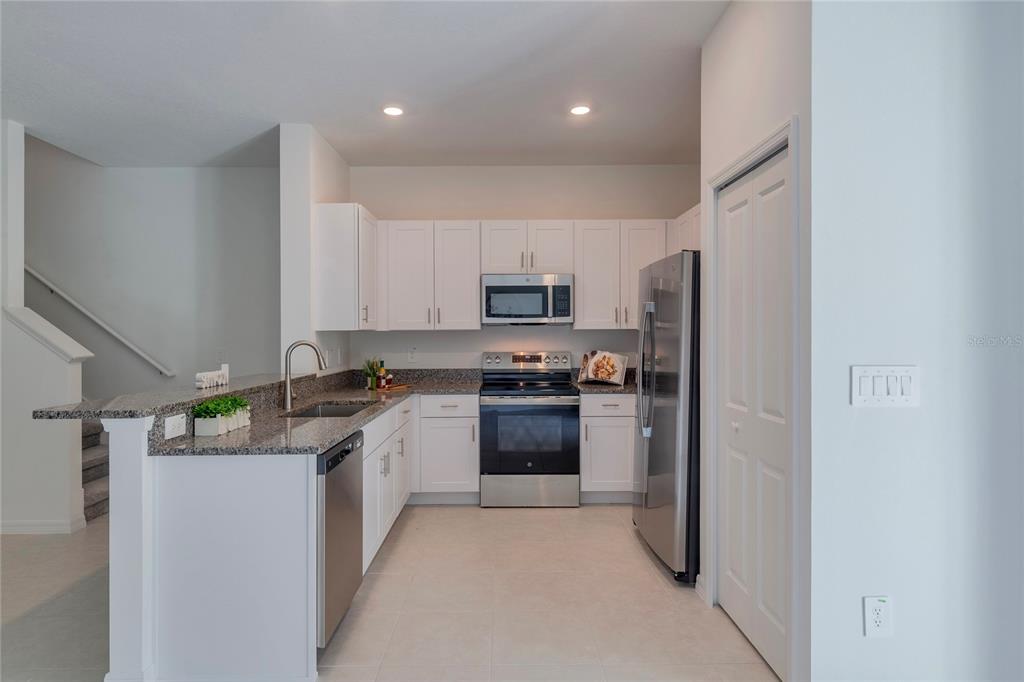 11091 Wishing Cloud Road Land O Lakes, FL 34638 - Photo 6 of 25 a kitchen with stainless steel appliances granite countertop a refrigerator and a stove top oven