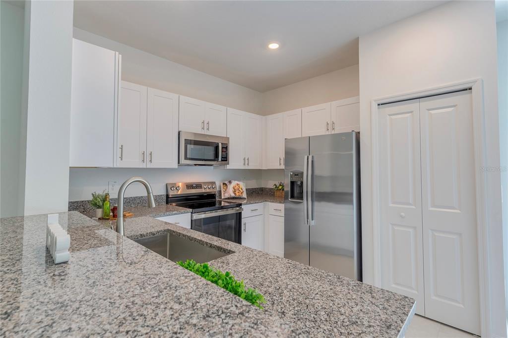 11091 Wishing Cloud Road Land O Lakes, FL 34638 - Photo 8 of 25 a kitchen with granite countertop a refrigerator and a sink