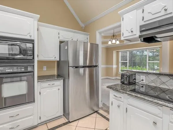 a kitchen with appliances a sink and cabinets