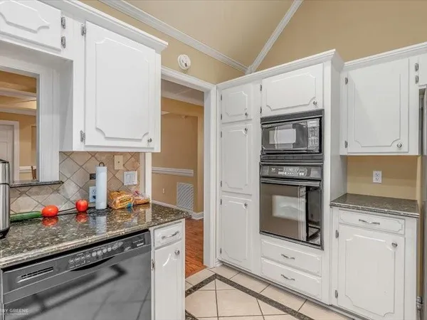 a kitchen with granite countertop white cabinets and appliances