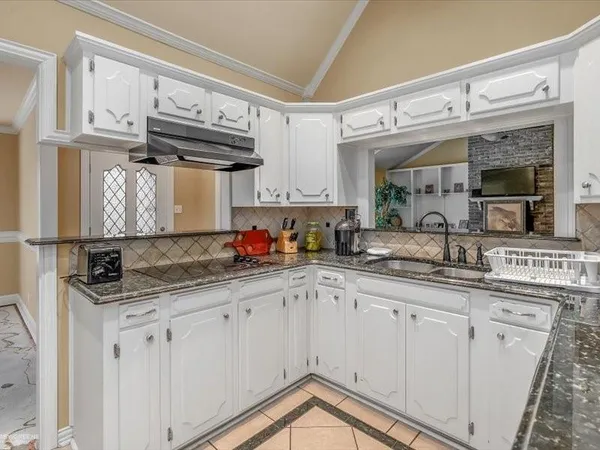 a kitchen with granite countertop a sink and cabinets