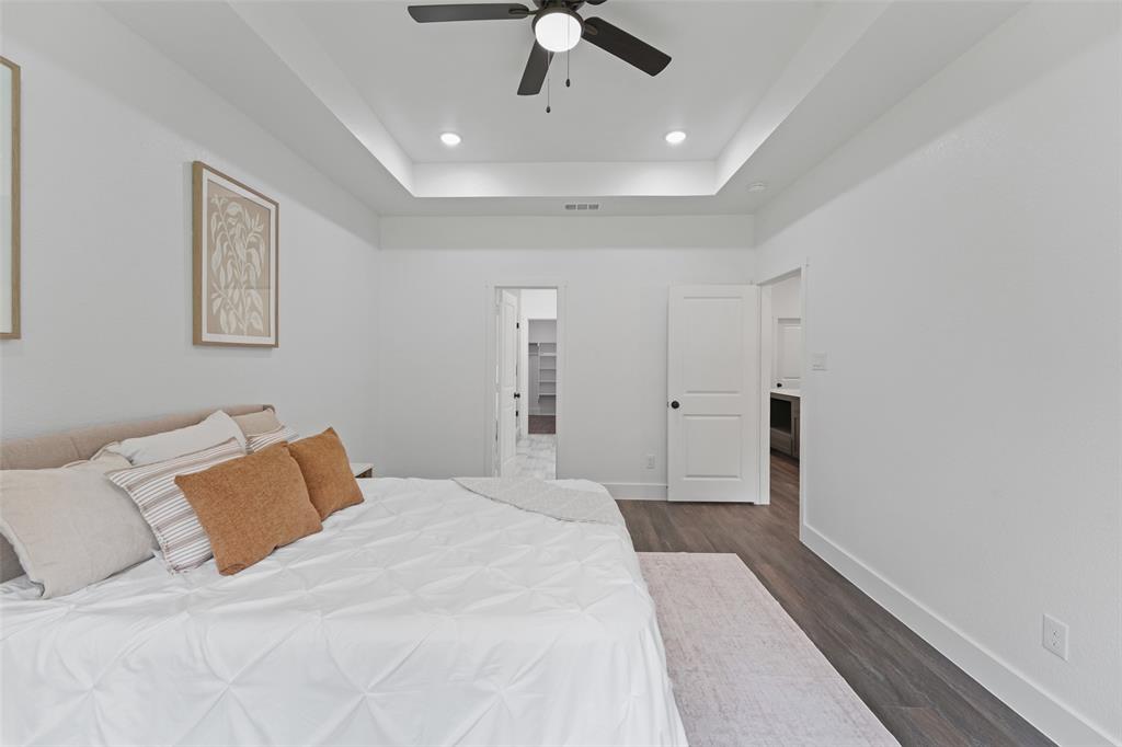 122 East Beachwood Loop Trinidad, TX 75163 - Photo 20 of 35 Spacious bedroom featuring a tray ceiling with recessed lighting and a ceiling fan, wood-finish flooring, and white interior doors with dark hardware