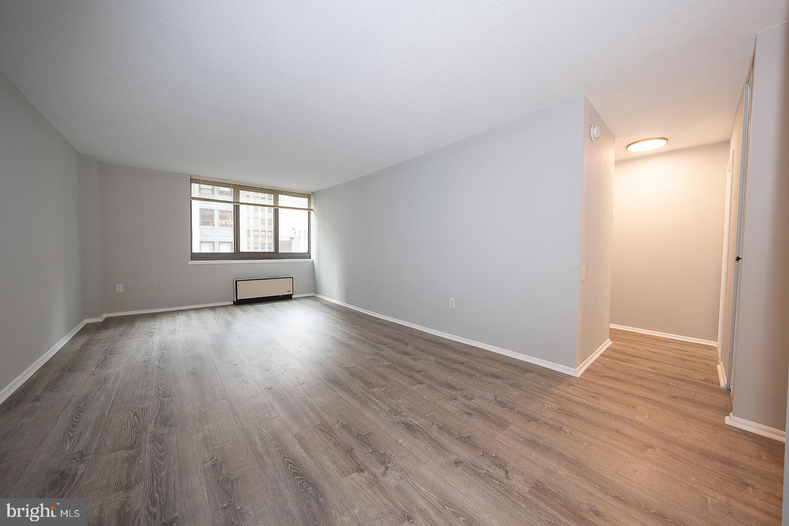 1420 Locust Street, Unit 7E Philadelphia, PA 19102 - Photo 2 of 24 an empty room with wooden floor and windows