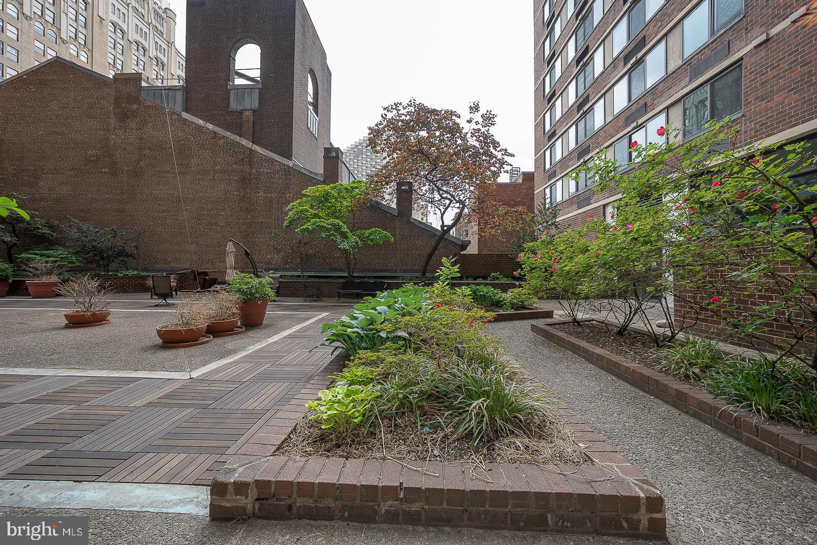 1420 Locust Street, Unit 7E Philadelphia, PA 19102 - Photo 21 of 24 a view of a street with potted plants and brick walls