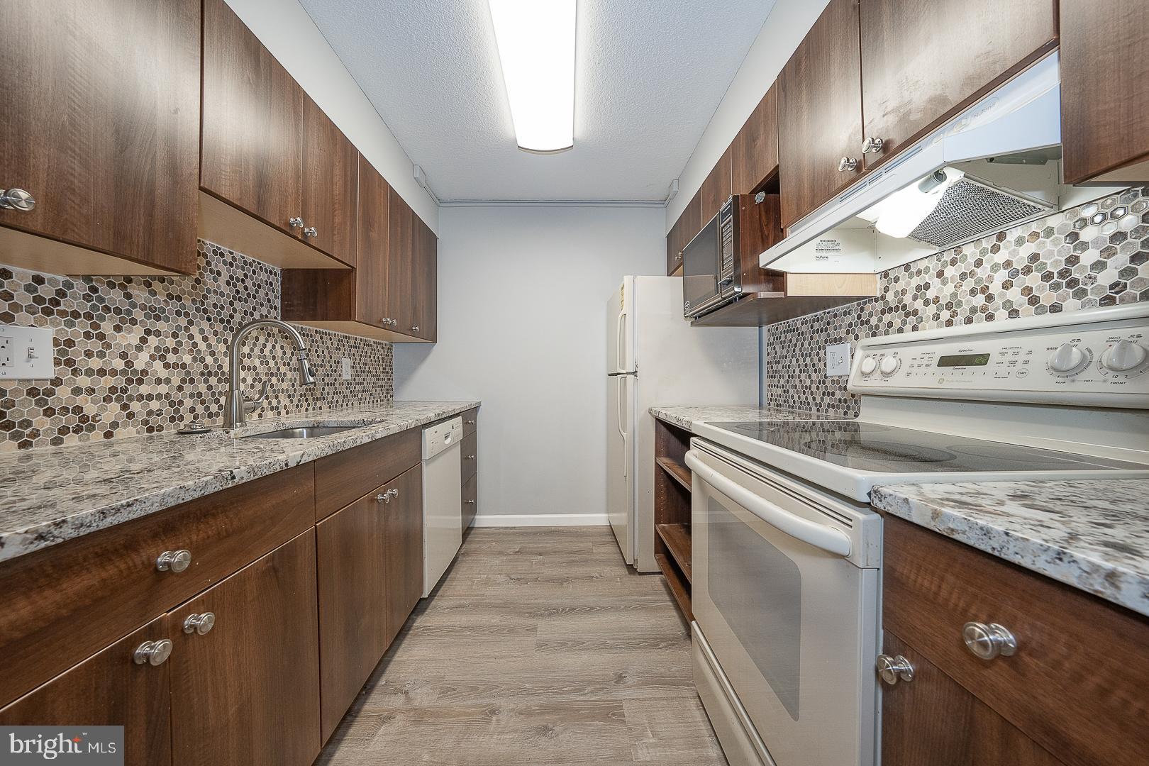 1420 Locust Street, Unit 7E Philadelphia, PA 19102 - Photo 4 of 24 a kitchen with stainless steel appliances granite countertop a sink and a stove