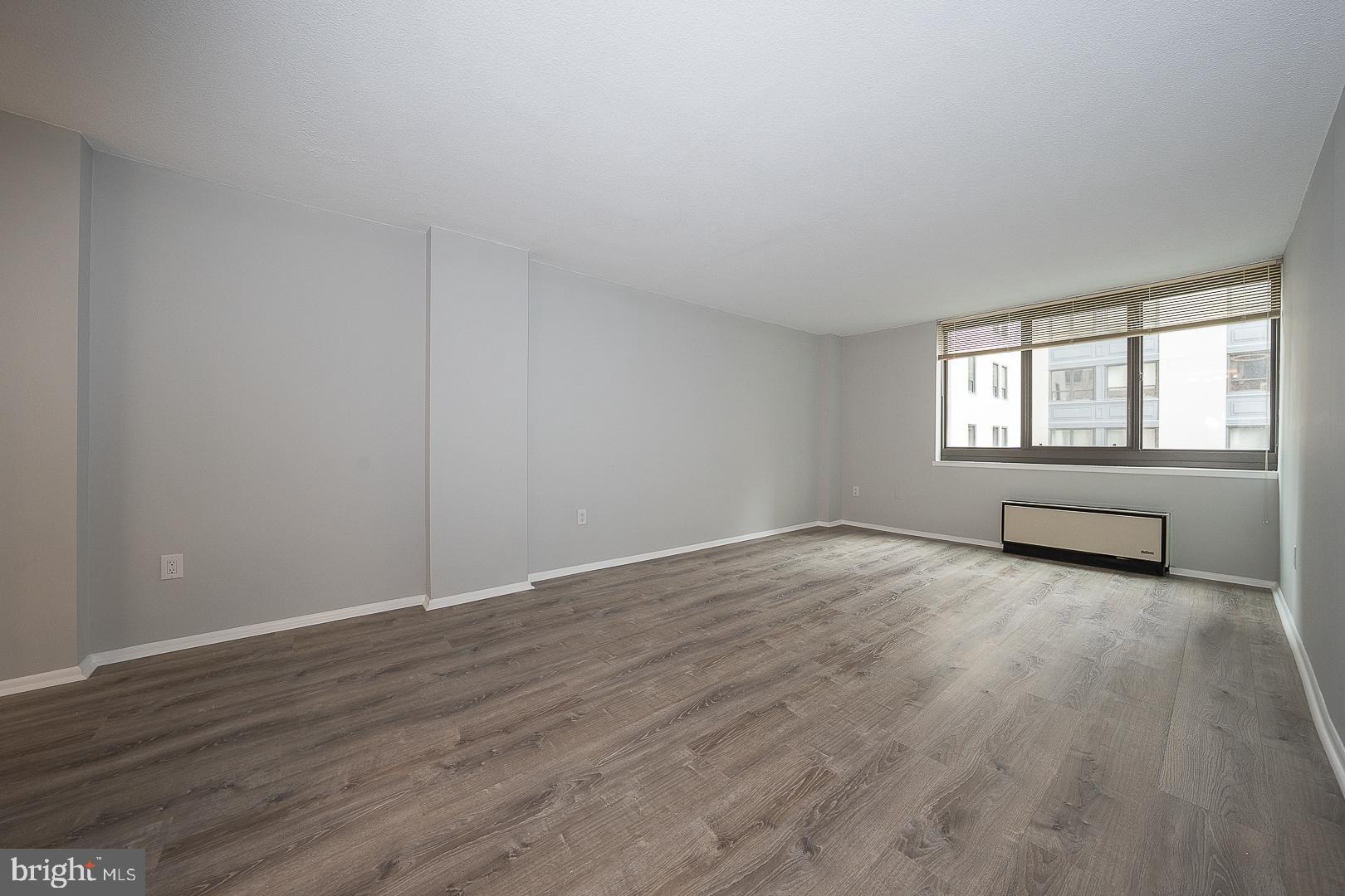 1420 Locust Street, Unit 7E Philadelphia, PA 19102 - Photo 5 of 24 an empty room with wooden floor and windows