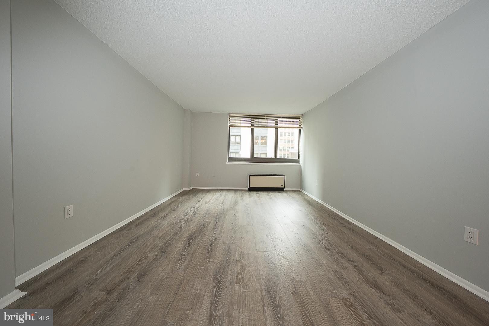 1420 Locust Street, Unit 7E Philadelphia, PA 19102 - Photo 6 of 24 an empty room with wooden floor and windows