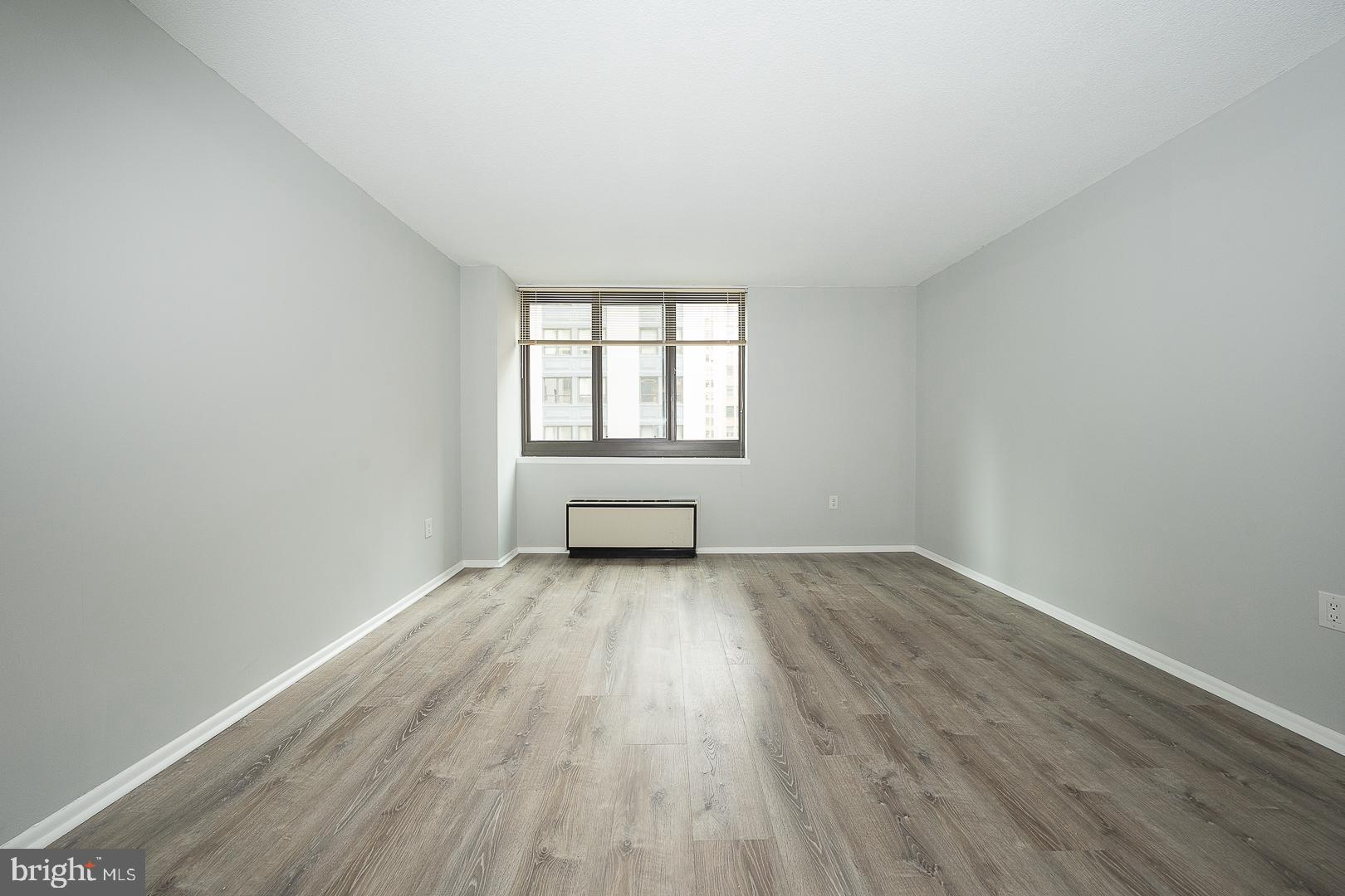 1420 Locust Street, Unit 7E Philadelphia, PA 19102 - Photo 9 of 24 an empty room with wooden floor and windows