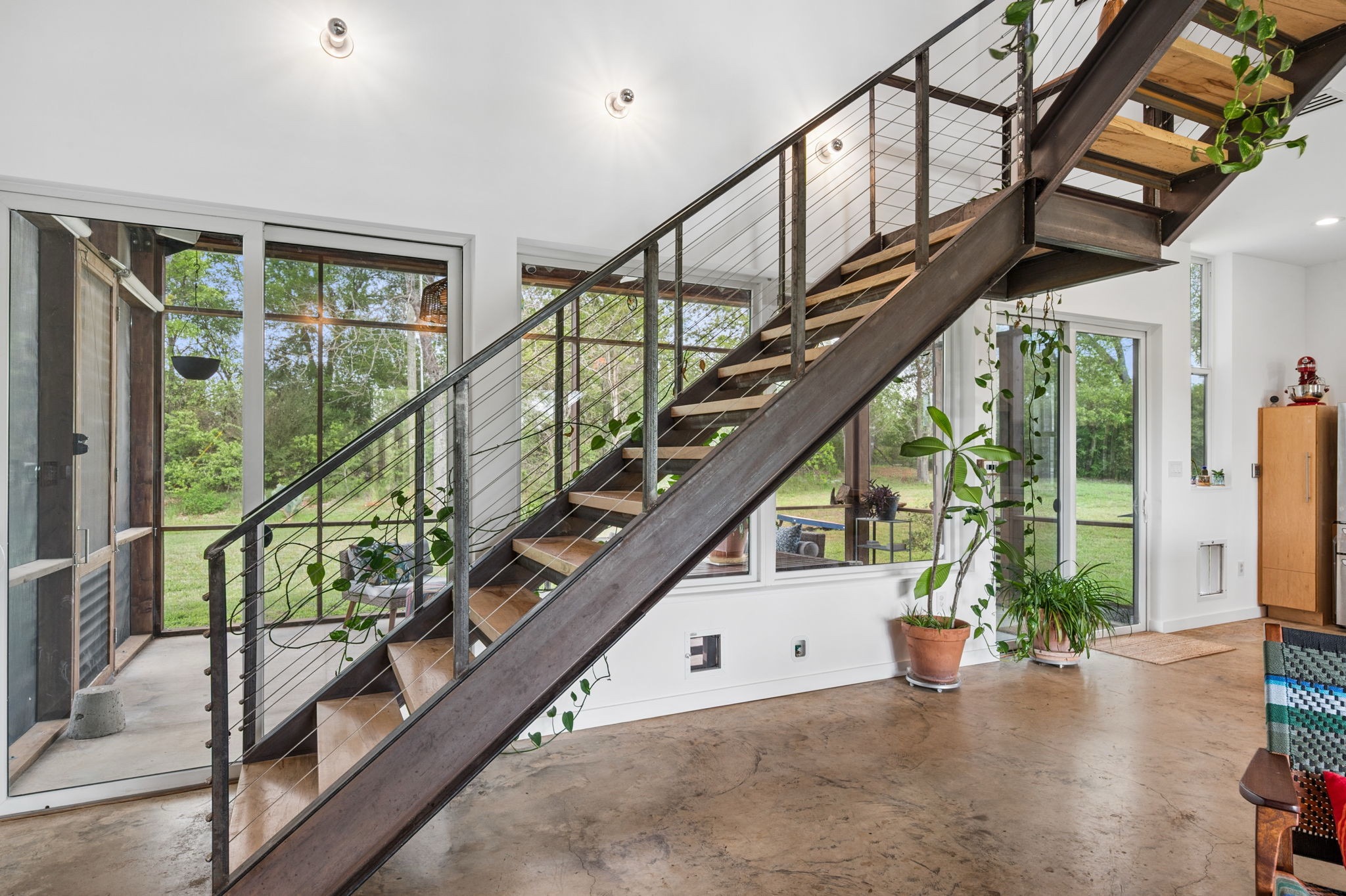 534 Old McDade Road Elgin, TX 78621 - Photo 22 of 40 Locally sourced pecan wood was used for the stairs, and the railings allow light to flow through the space.